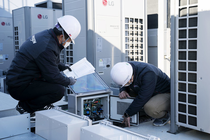 설명 : LG전자 직원들이 경상남도 김해시 진영휴게소에 설치된 하이브리드 히트펌프 시스템 에어컨을 점검하고 있다.